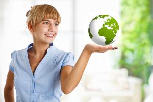 A smiling young woman holding the Earth in the palm of her hand